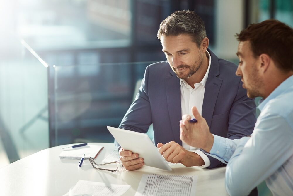 Deux collaborateurs en réunion analysant des données, illustrant les métiers commerciaux et le développement de la relation client - Recrutement OCEA Smart Building