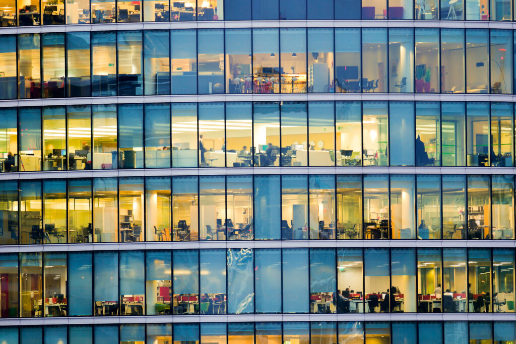 Façade de bureaux modernes avec espaces de travail visibles, illustrant la gestion des consommations d’énergie, l’optimisation des charges et le pilotage des bâtiments - Tertiaire - OCEA Smart Building – Groupe OCEA