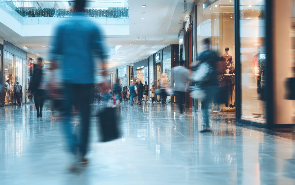 Centre commercial moderne avec flux de visiteurs sur escalators, illustrant la gestion des consommations d’énergie, la maîtrise des charges et l’exploitation des espaces commerciaux - Tertiaire - OCEA Smart Building – Groupe OCEA