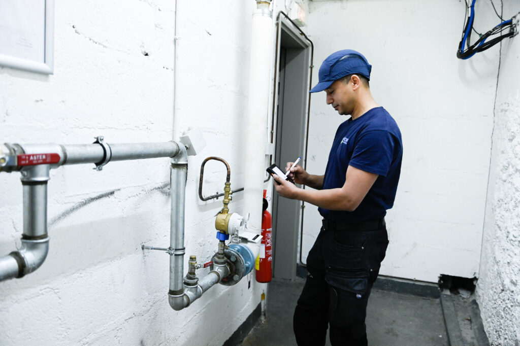 Technicien OCEA réalisant un relevé technique sur une installation de bâtiment avec un outil numérique - Recrutement OCEA Smart Building
