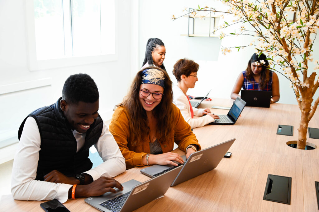 Collaborateurs travaillant ensemble autour d’une table dans un espace de bureau moderne, illustrant la formation, l’inclusion et la qualité de vie au travail au sein du Groupe OCEA