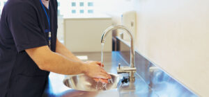 Personnel d’un établissement médico-social utilisant un point d’eau, illustrant la gestion des consommations d’eau et d’énergie et l’optimisation des usages au quotidien - OCEA Smart Building - Maîtrisez vos consommations