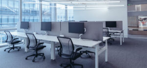 Espace de bureaux moderne avec postes de travail partagés, illustrant la répartition des charges, la gestion des consommations et les relations entre occupants dans les bâtiments tertiaires - OCEA Smart Building