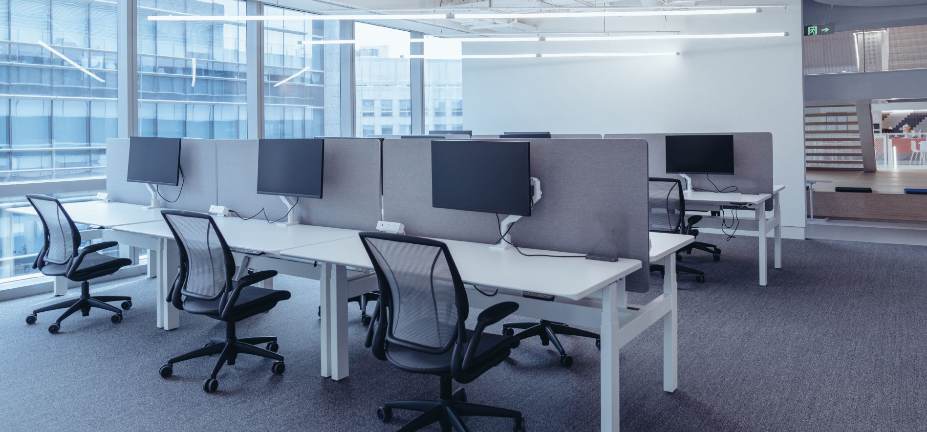 Espace de bureaux moderne avec postes de travail partagés, illustrant la répartition des charges, la gestion des consommations et les relations entre occupants dans les bâtiments tertiaires - OCEA Smart Building