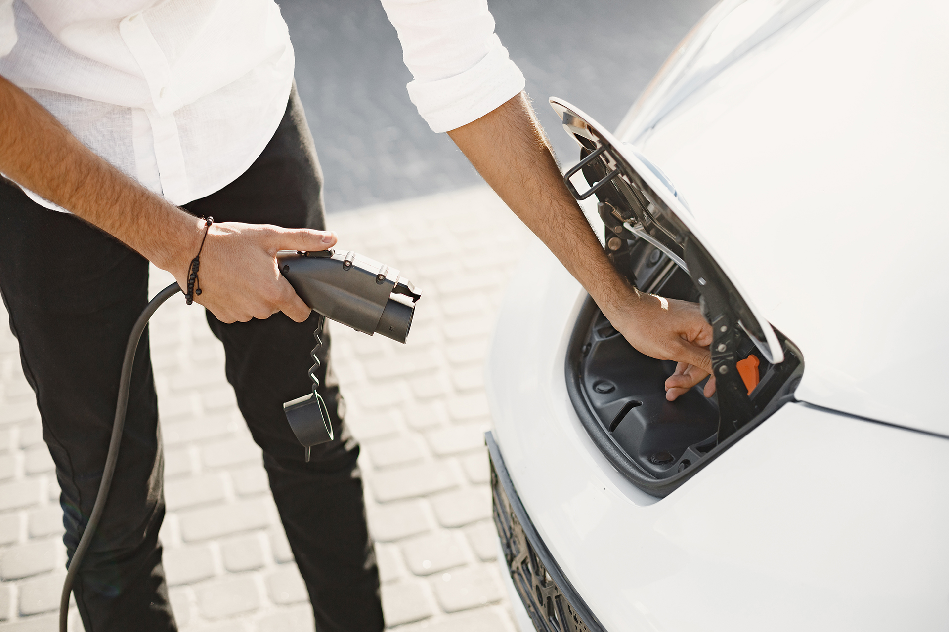 Personne chargeant sa voiture électrique grâce à une borne de recharge